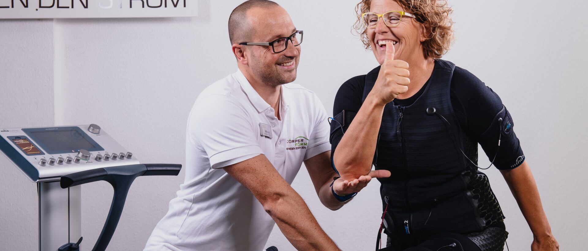 Trainer Manuel Klandt mit einer Kundin im EMS Outfit während des Trainings