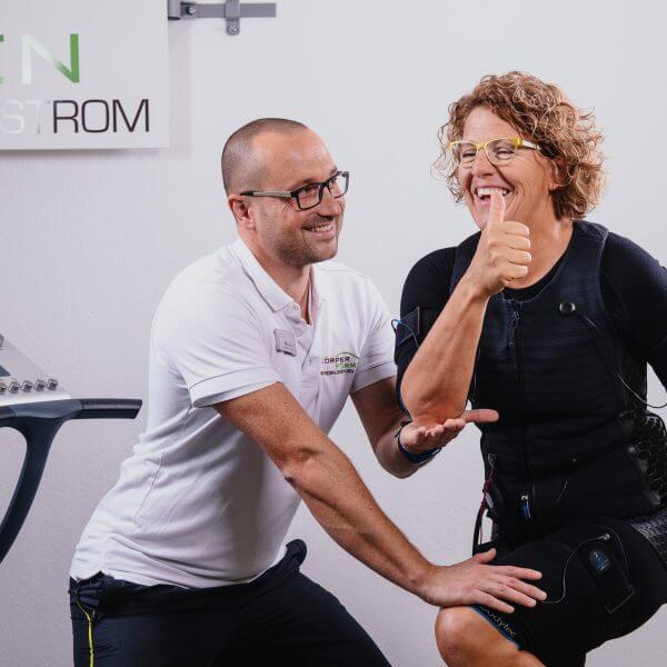 Trainer Manuel Klandt mit einer Kundin im EMS Outfit während des Trainings