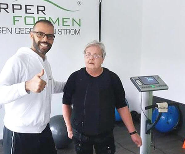 Trainer mit einer Kundin am EMS Gerät